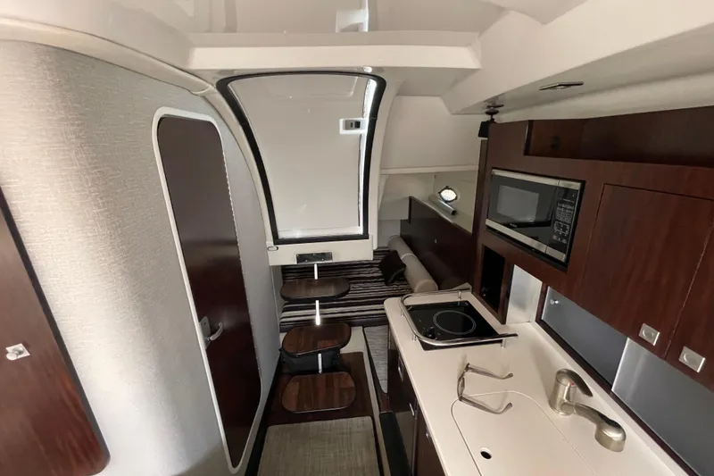 Slide: The Image of Interior of a 2019 Monterey 295 Sport Yacht featuring a modern kitchenette and seating area. - 29