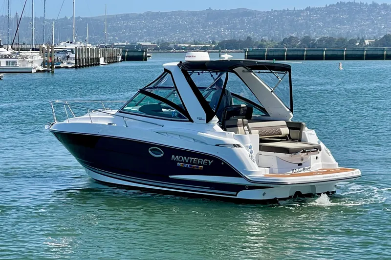 Slide: The Image of 2019 Monterey 295 Sport Yacht cruising on a sunny day in a scenic marina. - 3