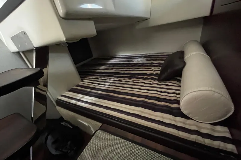 Slide: The Image of Interior cabin of 2019 Monterey 295 Sport Yacht with striped bedding and cushions. - 31