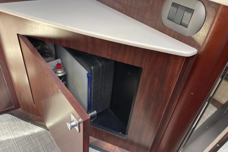 Slide: The Image of Open cabinet in 2019 Monterey 295 Sport Yacht with spray can and storage box. - 33