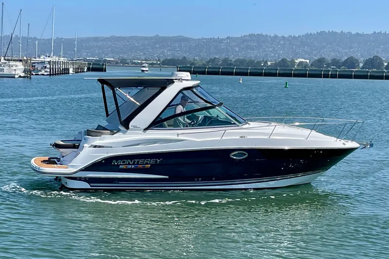 Slide: The Image of 2019 Monterey 295 Sport Yacht cruising on a sunny day in a marina. - 6