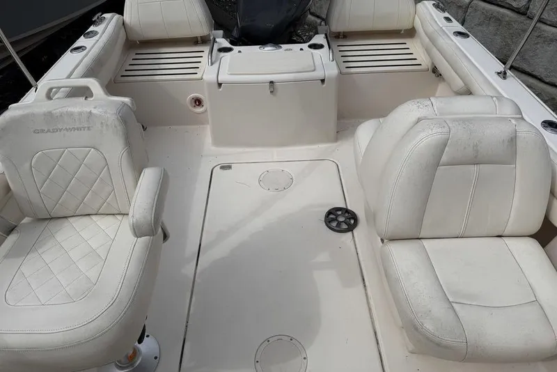 Slide: The Image of 2019 Grady-White Freedom 215 boat interior with white seating and storage compartments. - 17