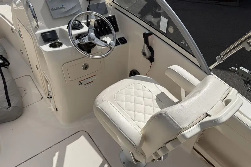 Slide: The Image of 2019 Grady-White Freedom 215 boat cockpit with steering wheel and cushioned seat. - 7