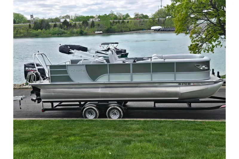 The Image of 2020 Bentley Pontoons 220 Elite Swingback Dual Captain on trailer by a lake. - 0