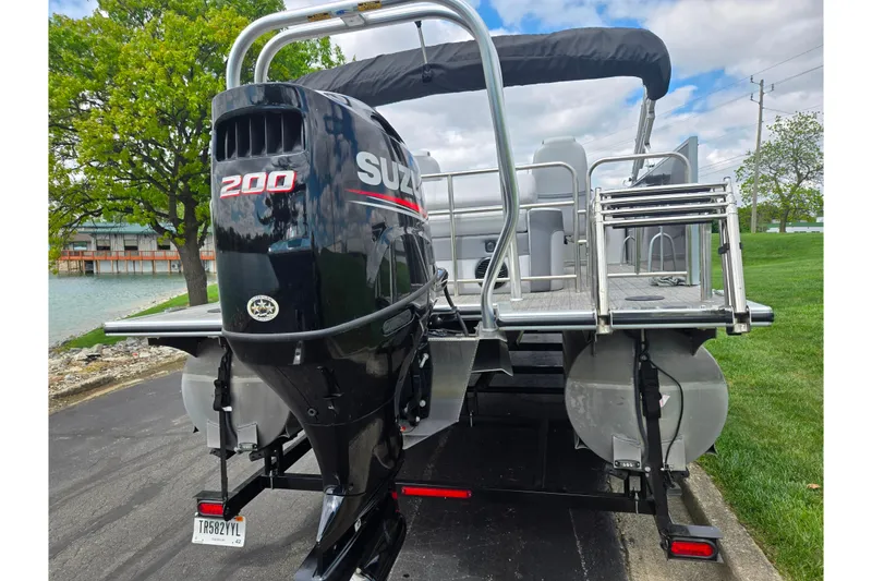 Slide: The Image of 2020 Bentley Pontoons 220 Elite with Suzuki 200 outboard motor, docked near a lake. - 2