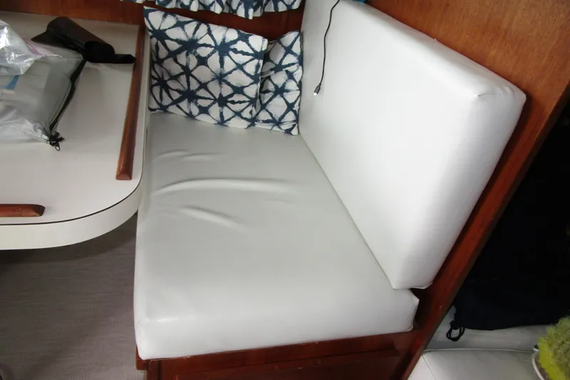 Slide: The Image of Interior seating of 1984 Tollycraft 26 Sedan with white cushions and patterned pillows. - 13