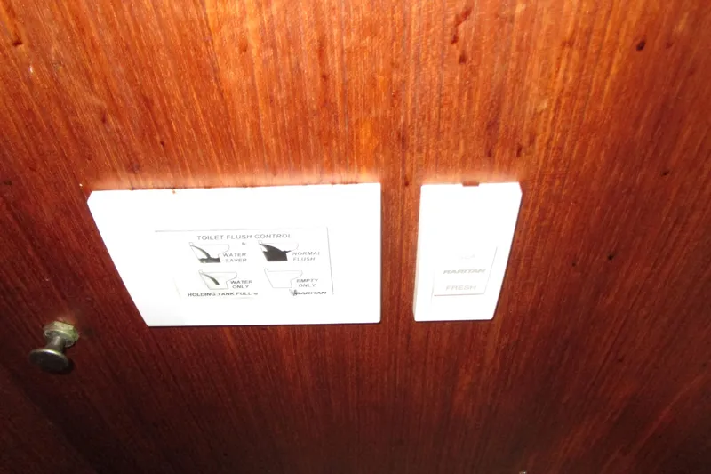 Slide: The Image of 1984 Tollycraft 26 Sedan toilet flush control panel on wooden surface. - 18