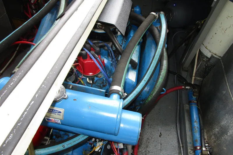 Slide: The Image of Engine compartment of a 1984 Tollycraft 26 Sedan, featuring blue components and hoses. - 19
