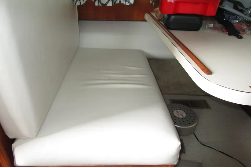 Slide: The Image of Interior of 1984 Tollycraft 26 Sedan with white cushioned seating and table. - 22