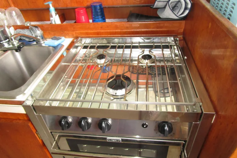 Slide: The Image of 1984 Tollycraft 26 Sedan kitchen with stove and sink in wooden interior. - 6
