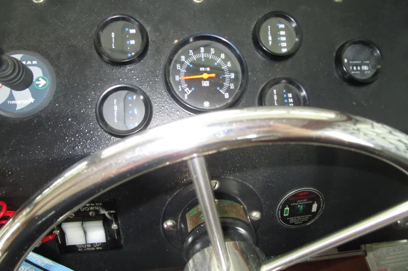 Slide: The Image of Dashboard of a 1984 Tollycraft 26 Sedan boat with gauges and steering wheel. - 8