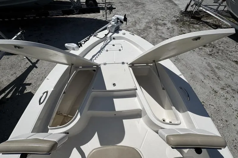 Slide: The Image of 2018 Robalo 226 Cayman boat deck with open storage compartments and trolling motor. - 10