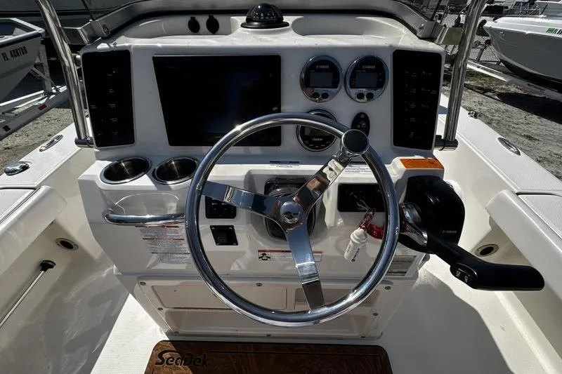 Slide: The Image of 2018 Robalo 226 Cayman boat dashboard with steering wheel and control panel. - 15