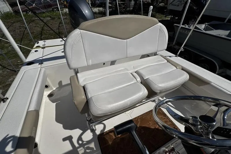 Slide: The Image of 2018 Robalo 226 Cayman boat interior with white seating and steering wheel. - 18