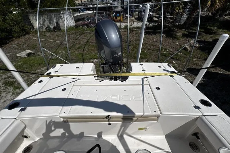Slide: The Image of 2018 Robalo 226 Cayman boat with outboard motor, docked outdoors. - 19