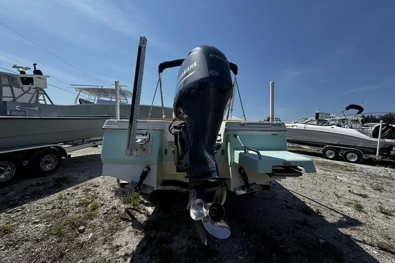 Slide: The Image of 2018 Robalo 226 Cayman boat with Yamaha outboard motor, parked on gravel. - 2