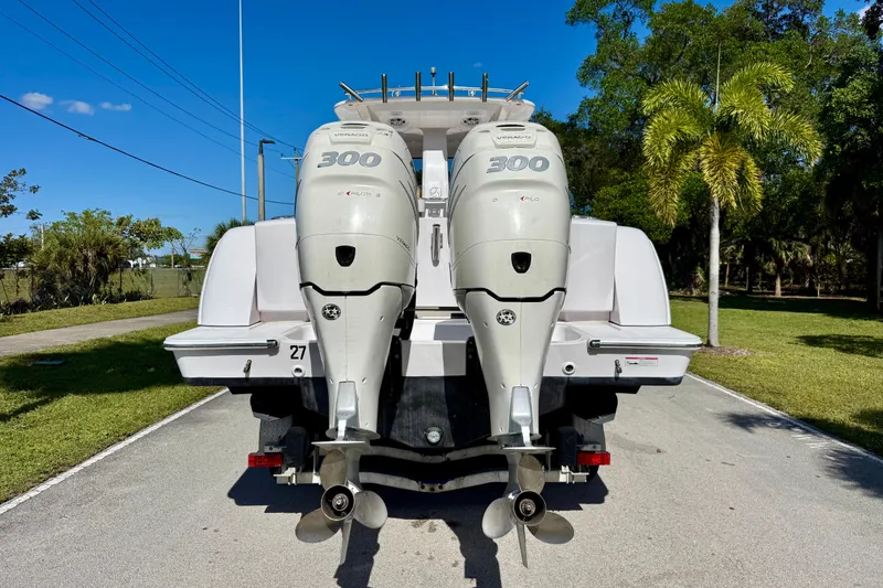 Slide: The Image of 2013 Belzona 32 CC boat with twin 300 horsepower outboard engines, parked on a sunny day. - 11