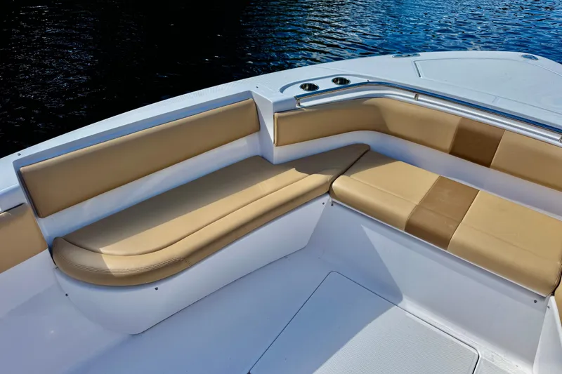 Slide: The Image of 2013 Belzona 32 CC boat with tan cushioned seating, on calm water. - 15