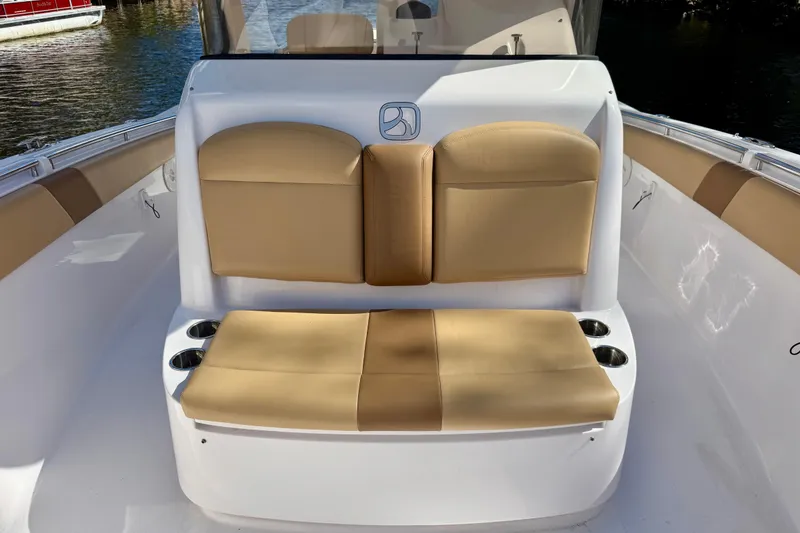 Slide: The Image of 2013 Belzona 32 CC boat with tan cushioned seating and cup holders. - 19