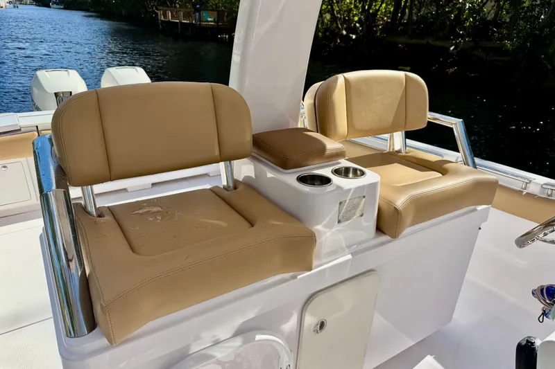 Slide: The Image of 2013 Belzona 32 CC boat with tan cushioned seating and cup holders on deck. - 21