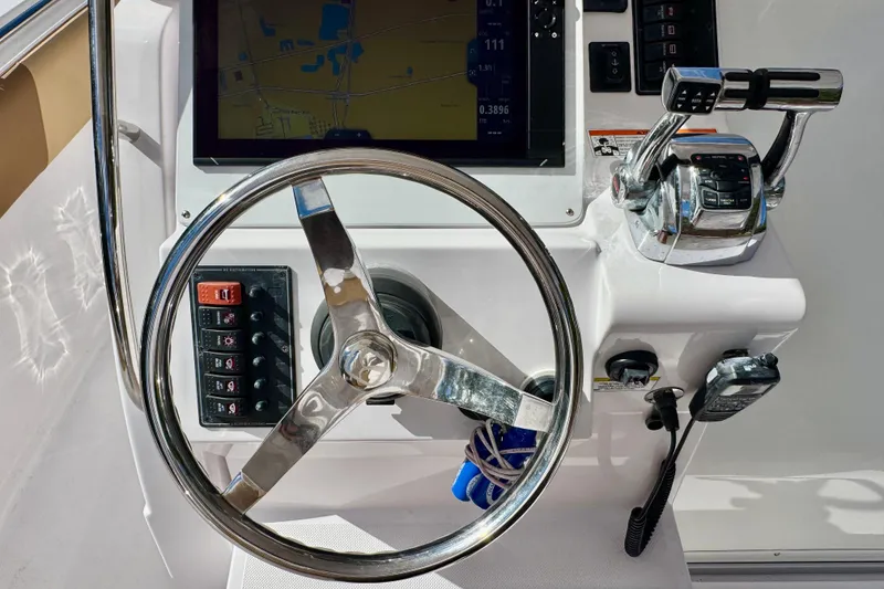 Slide: The Image of Control panel of a 2013 Belzona 32 CC boat with steering wheel and navigation equipment. - 25