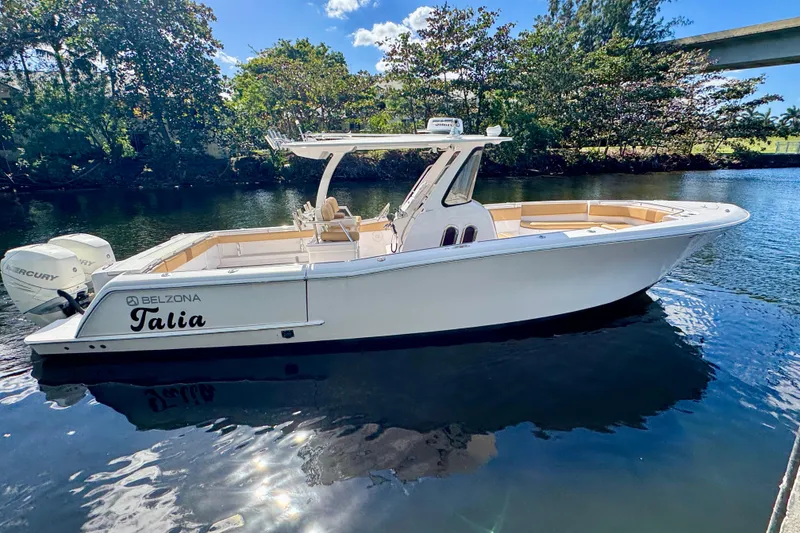 Slide: The Image of 2013 Belzona 32 CC boat named "Talia" on a calm river under a sunny sky. - 3