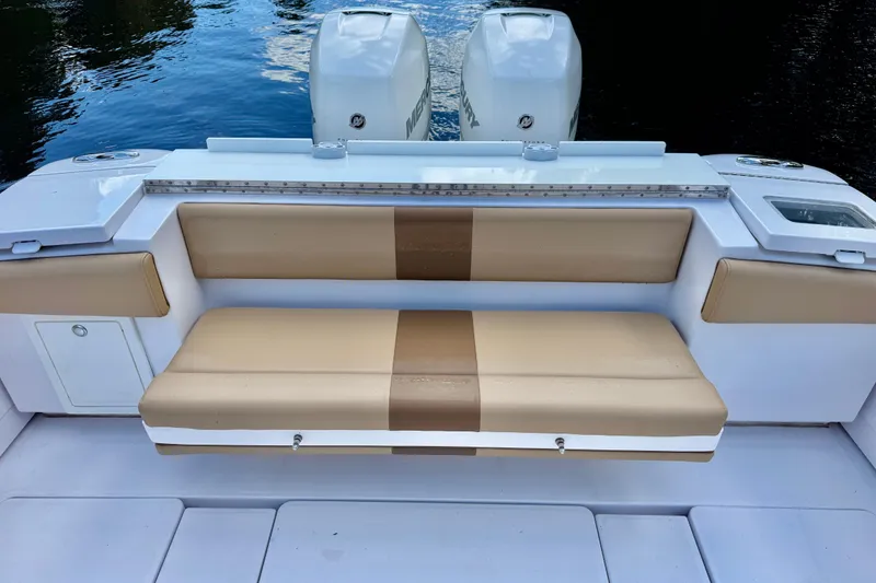 Slide: The Image of 2013 Belzona 32 CC boat with tan seating and dual Mercury engines. - 30