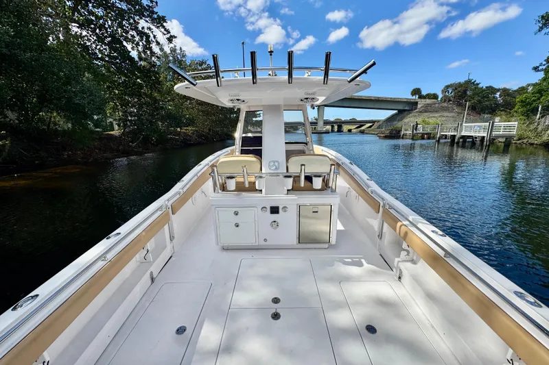 Slide: The Image of 2013 Belzona 32 CC boat on a calm river under a blue sky. - 31