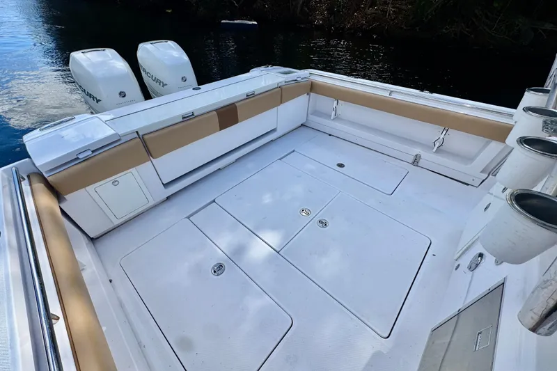 Slide: The Image of 2013 Belzona 32 CC boat deck with twin Mercury engines, spacious seating, and rod holders. - 34