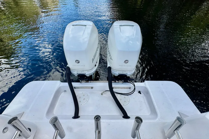 Slide: The Image of Twin Mercury outboard engines on a 2013 Belzona 32 CC boat, docked on calm water. - 39