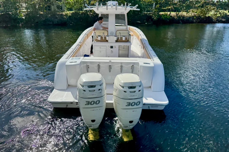 Slide: The Image of 2013 Belzona 32 CC boat with dual 300 horsepower engines on a calm waterway. - 5