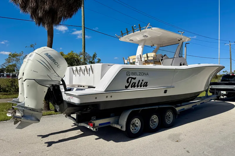 Slide: The Image of 2013 Belzona 32 CC boat on trailer with Mercury engine, parked outdoors. - 9