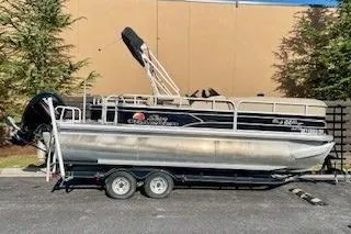 The Image of 2016 Sun Tracker Party Barge 22 XP3 pontoon boat on trailer, parked outdoors. - 0