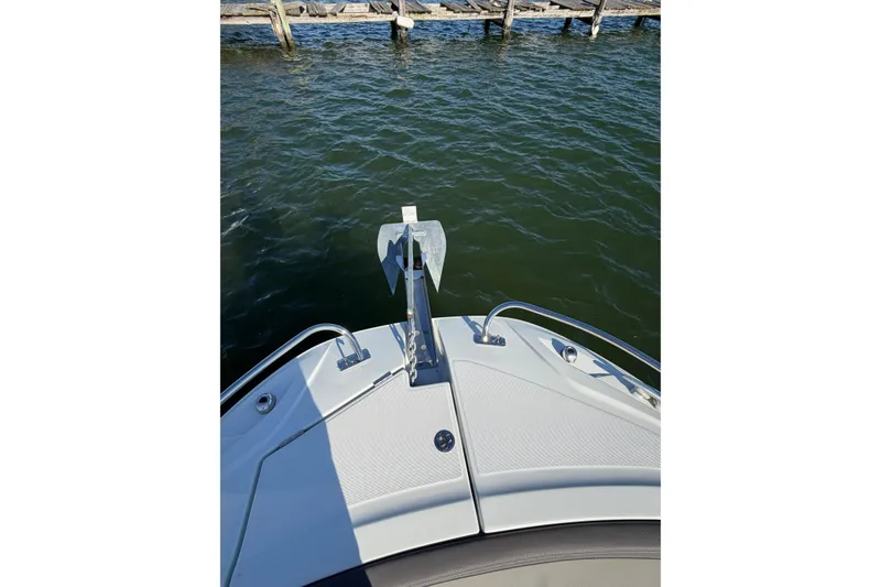 Slide: The Image of 2024 Jeanneau Leader 9.0 CC boat bow with anchor, docked on calm water. - 14