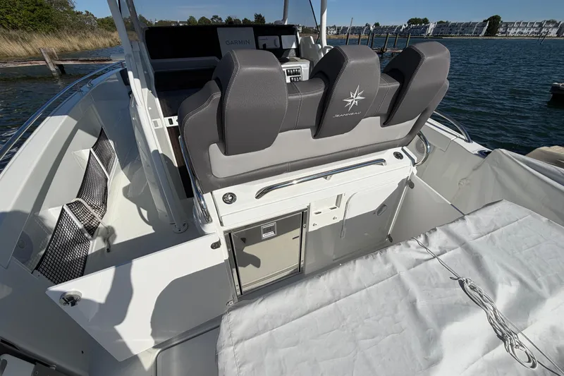 Slide: The Image of 2024 Jeanneau Leader 9.0 CC boat interior with seating and storage, docked by the water. - 3