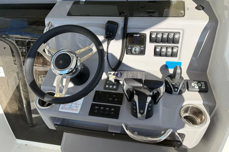 Slide: The Image of 2024 Jeanneau Leader 9.0 CC helm with steering wheel, controls, and switches. - 5