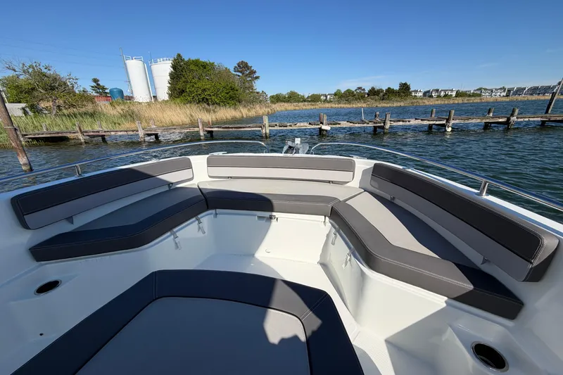 Slide: The Image of 2024 Jeanneau Leader 9.0 CC boat with spacious seating, docked by a scenic waterfront. - 9