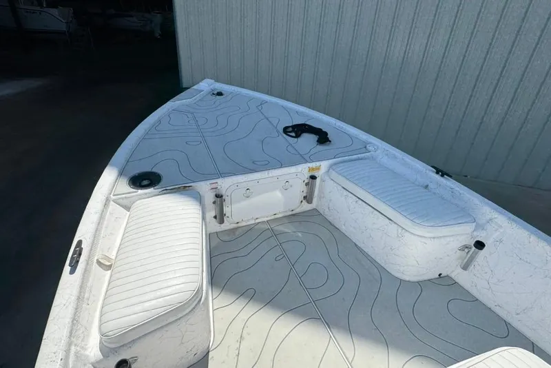 Slide: The Image of 2005 Kenner 21 VX boat interior with white seating and patterned flooring. - 11