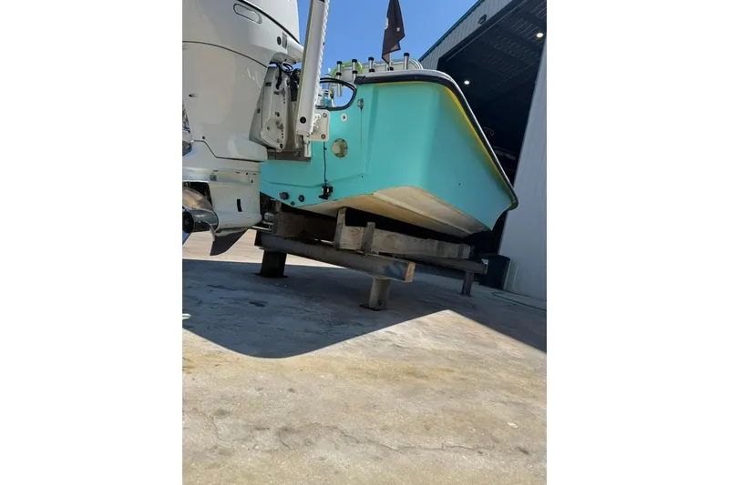 Slide: The Image of 2005 Kenner 21 VX boat on stand, turquoise hull, outdoor setting. - 12
