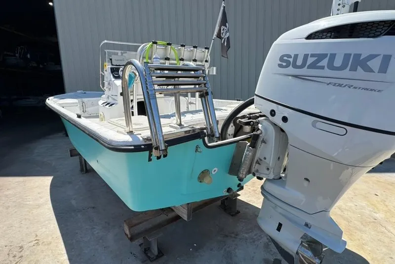 Slide: The Image of 2005 Kenner 21 VX boat with Suzuki four-stroke engine, parked in a garage. - 4