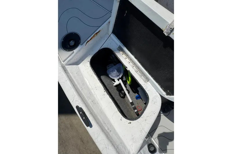 Slide: The Image of Open storage compartment on 2005 Kenner 21 VX boat, containing fishing gear and accessories. - 8