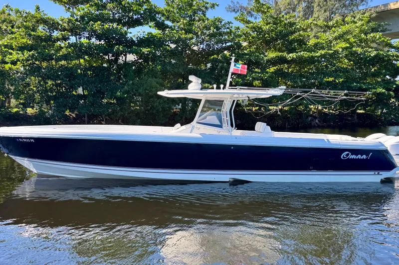 The Image of 2012 Intrepid 400 Center Console boat on calm water, surrounded by lush greenery. - 0