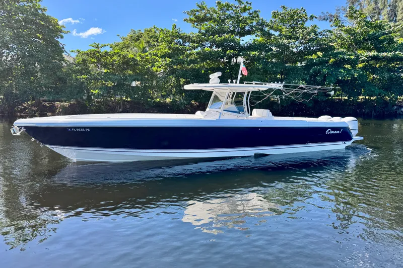 Slide: The Image of 2012 Intrepid 400 Center Console boat on calm water, surrounded by lush greenery. - 1