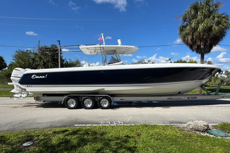 Slide: The Image of 2012 Intrepid 400 Center Console boat on trailer, parked roadside under clear blue sky. - 12