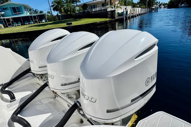 Slide: The Image of Triple Yamaha outboard engines on a 2012 Intrepid 400 Center Console boat by a canal. - 36