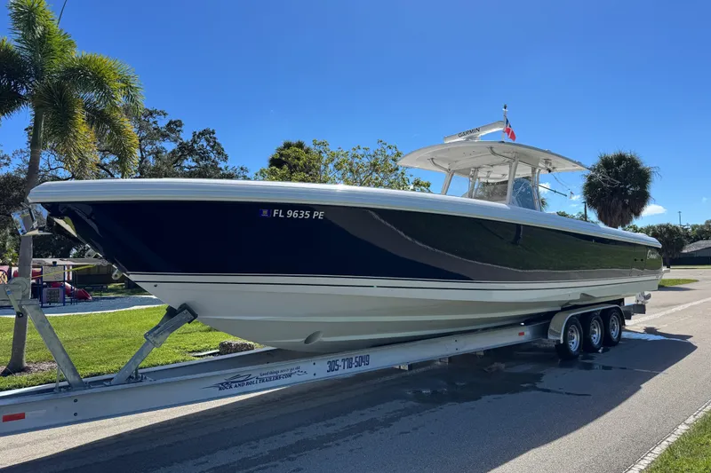 Slide: The Image of 2012 Intrepid 400 Center Console boat on trailer, parked outdoors under clear blue sky. - 7