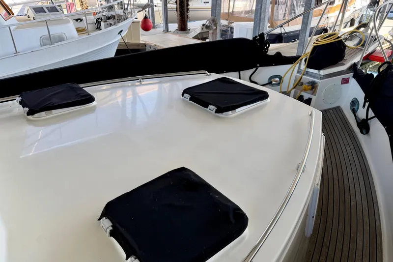 Slide: The Image of 1991 Grand Banks 36 Europa yacht deck with covered hatches in marina setting. - 14