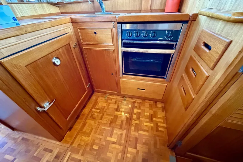 Slide: The Image of Wooden kitchen interior of 1991 Grand Banks 36 Europa yacht with oven and cabinetry. - 23