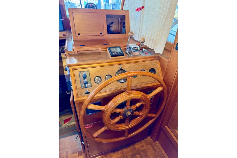 Slide: The Image of Wooden helm station of 1991 Grand Banks 36 Europa yacht, featuring classic controls and gauges. - 26