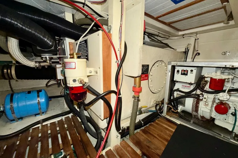 Slide: The Image of Engine room of a 1991 Grand Banks 36 Europa, showcasing mechanical components and wiring. - 50